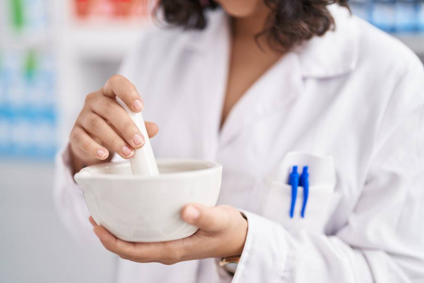 Young woman pharmacist mixing medicine at pharmacy - Photo, image