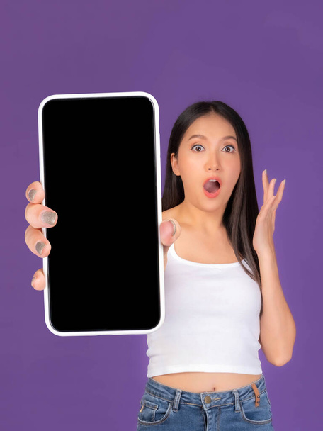 Beautiful Asian brunette woman cute girl in white tank top ,Excited surprised girl showing big smart phone with blank screen , black screen isolated purple background , Mock Up Image - Fotoğraf, Görsel