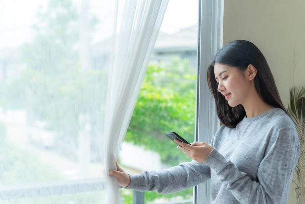 Lifestyle schöne Schönheit Frau Asiatische süße Mädchen fühlen sich glücklich mit Smartphone im Schlafzimmer zu Hause - Foto, Bild