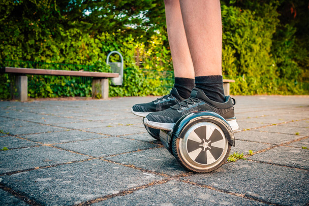 Teenager riding a hoverboard at schoolyard - self-balancing scooter, levitating board used for personal transportation - Photo, Image
