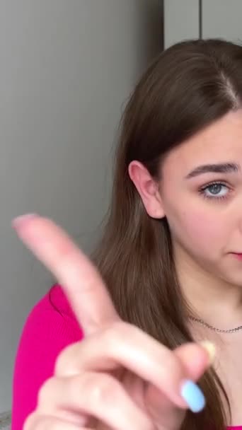 Een jong meisje toont een vinger no-no-no voor de camera ze kijkt naar ons en schudt met haar vinger - Video