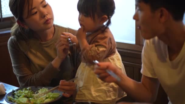 Genitori e bambini mangiano in un ristorante Yakiniku - Filmati, video