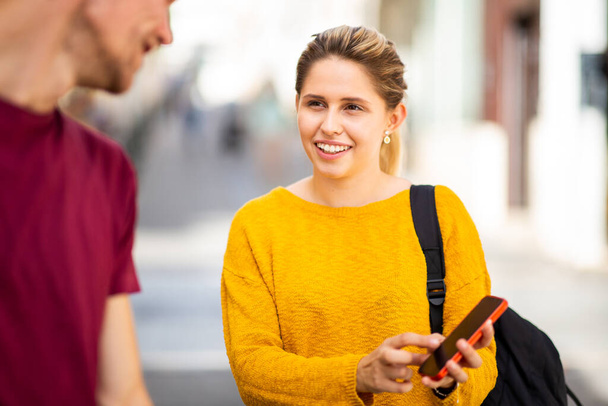 Feliz casal jovem turista usando o aplicativo de navegação no celular enquanto caminha na cidade - Foto, Imagem