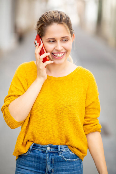 Portret pięknej młodej kobiety rozmawiającej przez telefon komórkowy spacerującej po mieście - Zdjęcie, obraz