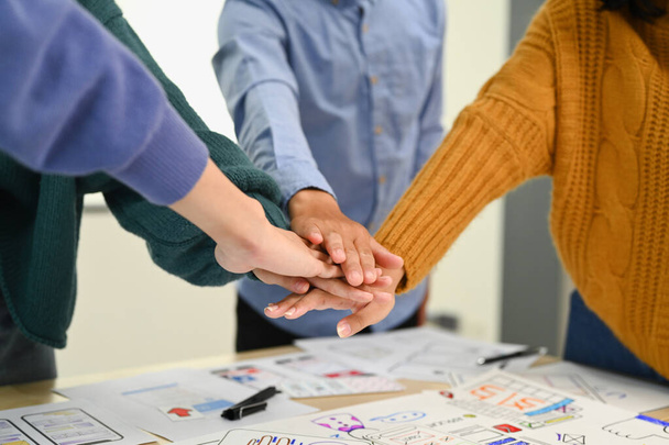 Cropped shot of startup businesspeople stacking hands together, celebrating completion of project, motivating and team building. - Фото, зображення