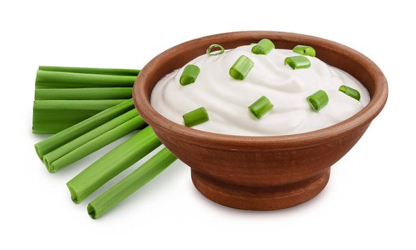 сметана або йогурт в керамічній мисці з зеленою цибулею ізольовані на білому тлі з повною глибиною різкості. - Фото, зображення