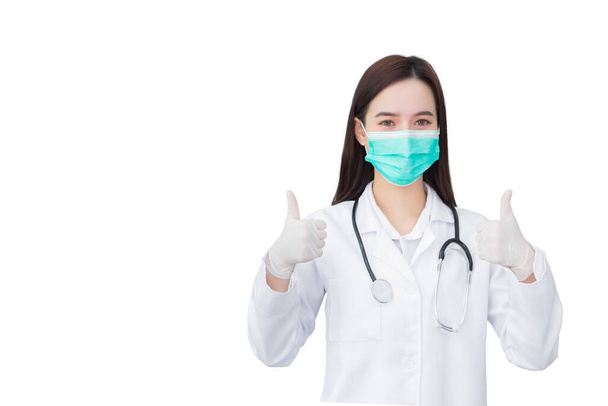 医療コートやフェイスマスクを身に着けているアジアの専門家女性医師は、病院での健康保護の概念に良い兆候としてthumpを示しています - 写真・画像