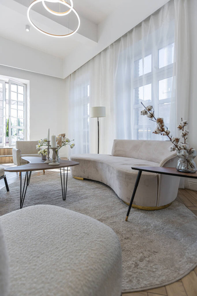 creative coffee table and fashionable upholstered furniture in the living room in a spacious open-plan apartment with a stylish modern bright design on a sunny day - Zdjęcie, obraz