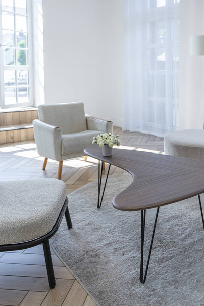 creative coffee table and fashionable upholstered furniture in the living room in a spacious open-plan apartment with a stylish modern bright design on a sunny day - Fotó, kép