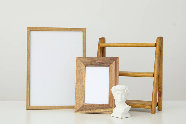 Κορνίζες φωτογραφιών με κενά στο τραπέζι σε λευκό φόντο - Φωτογραφία, εικόνα