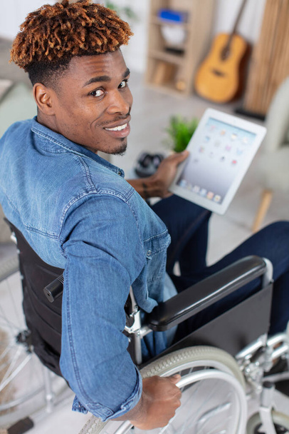 happy man on wheelchair using tablet - Foto, imagen