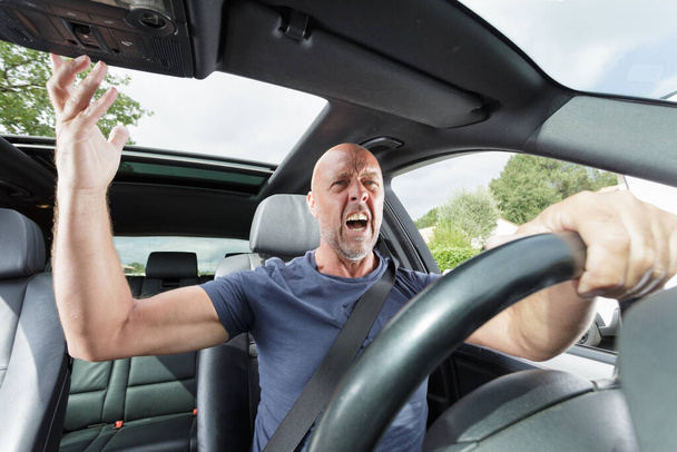 abusive senior male driver at the wheel of his car - Фото, изображение