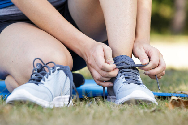 female runner tying her shoes for a jogging exercise - Fotoğraf, Görsel