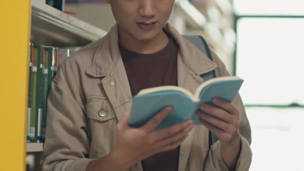 Затемнення знімка концентрованої книги для читання студентів у бібліотеці - Кадри, відео