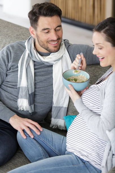 pregnant woman eating next to boyfriend - Фото, зображення