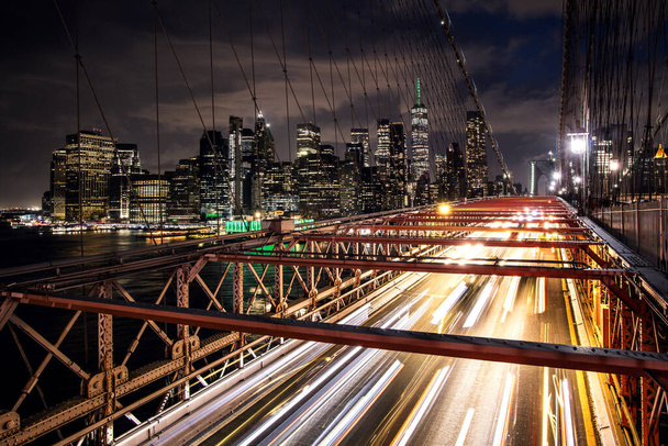 Brooklyn Köprüsü 'nden New York' a uzanan Manhattan silueti geceleri etkileyici mimari ve modern şehir manzarasını gözler önüne seriyor. - Fotoğraf, Görsel