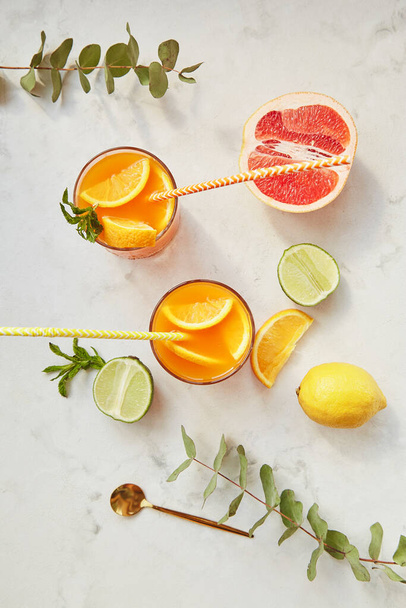 Nyári italok, citruskoktélok jéggel a szemüvegben. Frissítő nyári házi alkoholmentes koktélok. Méregtelenített ízesített víz - Fotó, kép