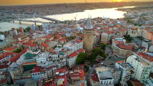 Z lotu ptaka widać Istambuł o zachodzie słońca w Turcji. Wiele budynków mieszkalnych wokół wieży Galata, droga wodna Golden Horn na tle - Materiał filmowy, wideo