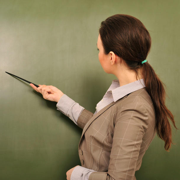 Portret van een jonge vrouw leraar permanent in de buurt van blackboard en exp - Foto, afbeelding