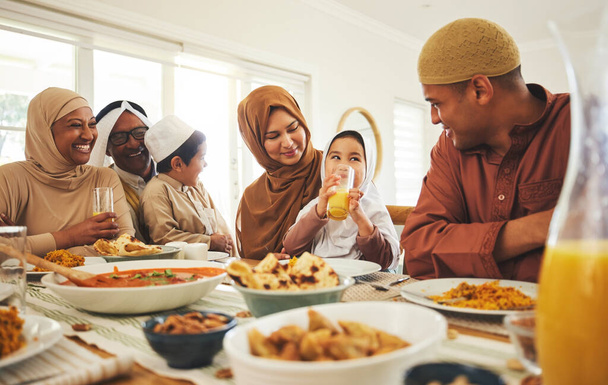 Comida, amor y musulmana con gran familia en la mesa para eid mubarak, celebración islámica y almuerzo. Festival de Ramadán, cultura e iftar con gente comiendo en casa para ayunar, islam y fiesta religiosa. - Foto, Imagen