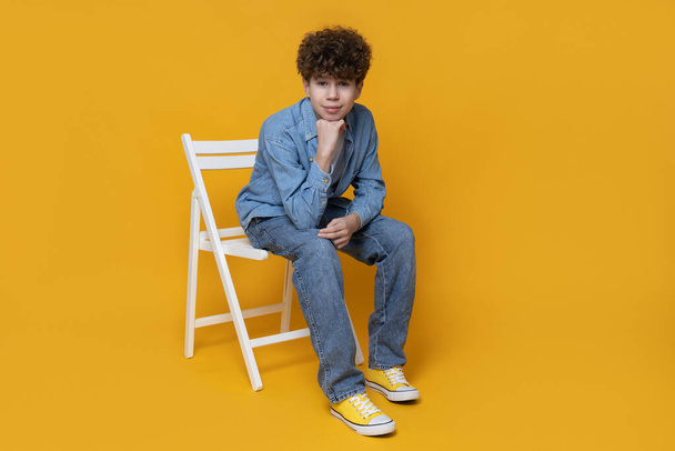 A teenager sits on a white chair - Foto, Bild