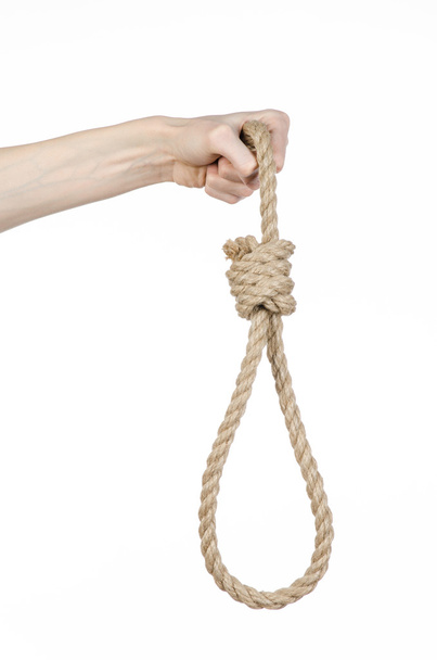 Lynching and suicide theme: man's hand holding a loop of rope for hanging on white isolated background - Foto, Imagem