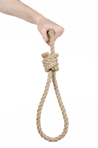Lynching and suicide theme: man's hand holding a loop of rope for hanging on white isolated background - Photo, Image