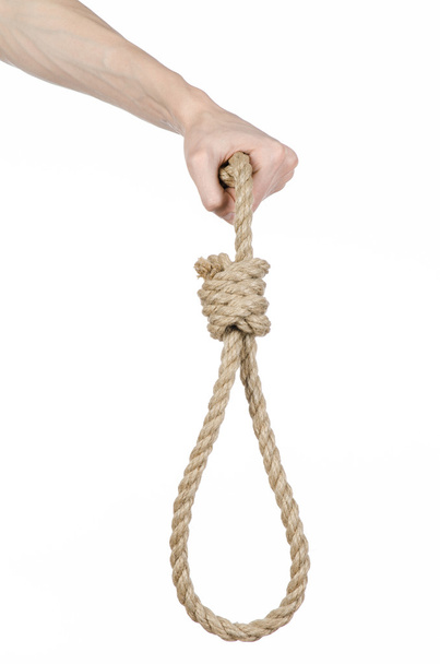 Lynching and suicide theme: man's hand holding a loop of rope for hanging on white isolated background - Foto, afbeelding