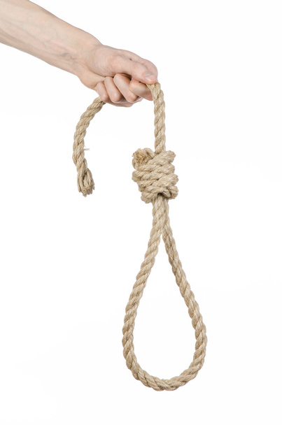 Lynching and suicide theme: man's hand holding a loop of rope for hanging on white isolated background - Zdjęcie, obraz