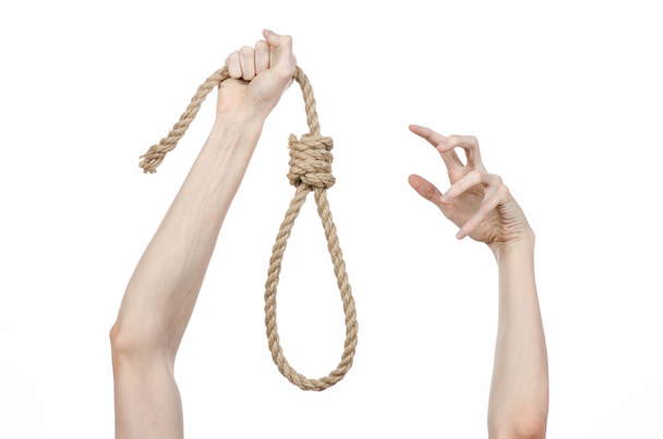Lynching and suicide theme: man's hand holding a loop of rope for hanging on white isolated background - Фото, изображение