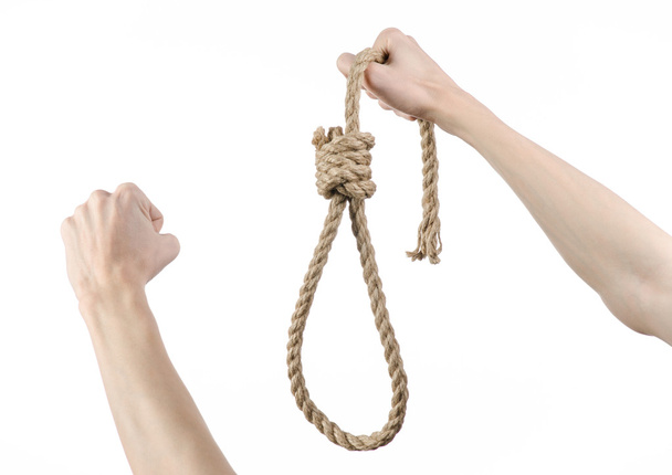 Lynching and suicide theme: man's hand holding a loop of rope for hanging on white isolated background - Fotó, kép