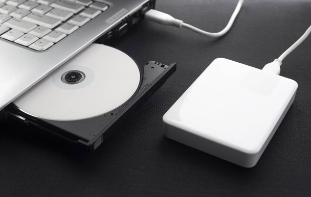 externí pevný disk připojený k notebooku, otevřený optický disk notebooku s diskem, chráněná data, Koncepce ukládání dat, na tmavém pozadí - Fotografie, Obrázek