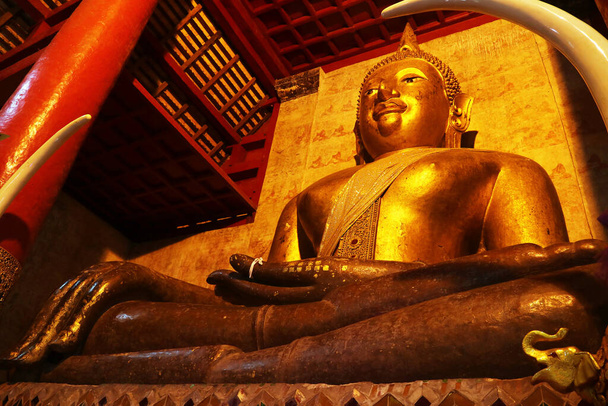 Prajaoluang Srinakonnan, Niesamowity 6 metrowy Złocony Obraz Buddy w Wielkiej Sali Sanktuarium Wat Phra Że Chang Kham Worawihan, Prowincja Nan, Północna Tajlandia - Zdjęcie, obraz