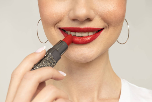 The girl paints her lips with red lipstick - Photo, Image