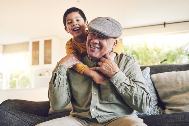 Hug, grandfather and boy with a smile, relax and love with quality time, cheerful and weekend break in a home. Male child, grandpa and kid embrace, bonding and portrait with joy, playful and loving. - 写真・画像