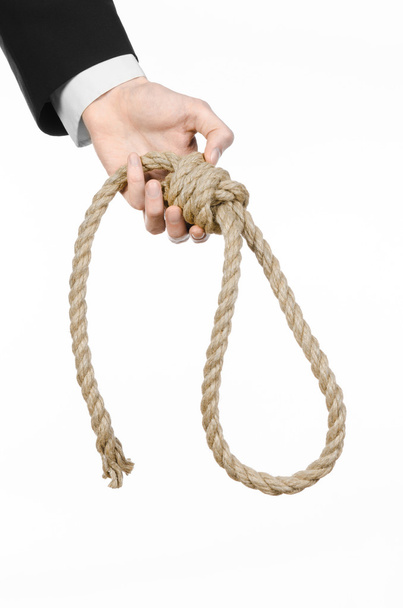 Suicide and business topic: Hand of a businessman in a black jacket holding a loop of rope for hanging on white isolated background - Foto, Imagem