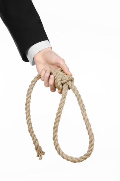 Suicide and business topic: Hand of a businessman in a black jacket holding a loop of rope for hanging on white isolated background - Φωτογραφία, εικόνα