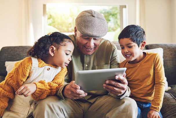 Young kids, grandfather and tablet, relax together and watch cartoon or e learning with games while at home. Bonding, love and spending quality time, old man and grandkids with gadget and internet. - Foto, Imagen