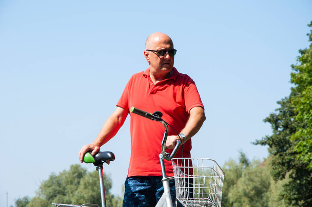 man with bicycle in summer. cyclist with sport bike outdoor. summertime activity recreation and active lifestyle. weekend travel and adventure. leisure and fun of man. - Photo, Image