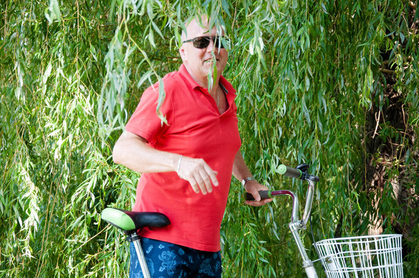 άνθρωπος με ποδήλατο το καλοκαίρι. ποδηλάτης με σπορ ποδήλατο υπαίθρια. καλοκαιρινή δραστηριότητα αναψυχή και ενεργό τρόπο ζωής. Σαββατοκύριακο ταξίδια και περιπέτεια. αναψυχή και διασκέδαση του ανθρώπου. - Φωτογραφία, εικόνα