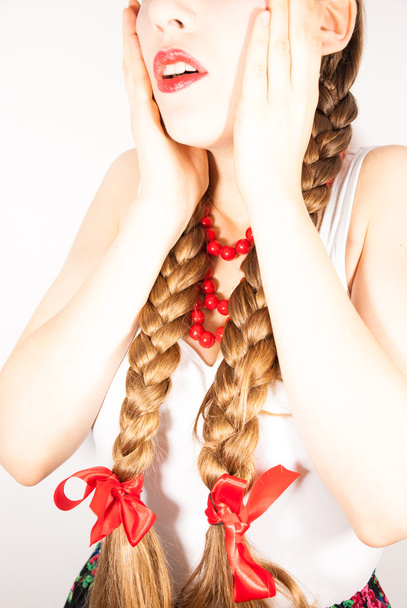 Egy fiatal gyönyörű nő, hosszú, szőke haja tresses egy lengyel népi ruha viselése - Fotó, kép