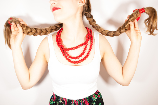 Una joven hermosa mujer con trenzas de pelo largo y rubio con un traje popular polaco
 - Foto, Imagen