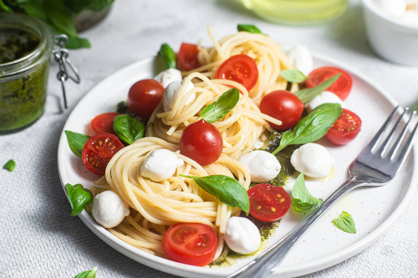Spaghetti with mozzarella, tomatoes, basil and pesto sauce. Pasta Caprese - Foto, Imagem