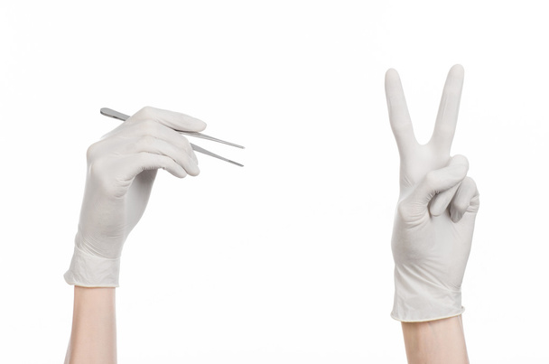 Thème Médecine et chirurgie : la main du médecin dans un gant blanc tenant une pince à épiler isolée sur fond blanc
 - Photo, image