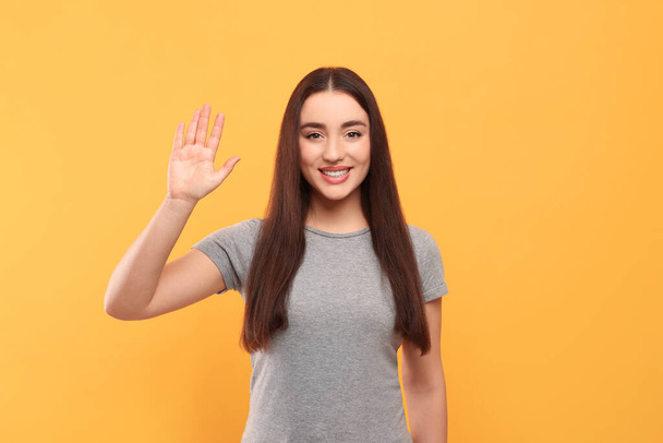 Happy woman giving high five on orange background - Foto, immagini