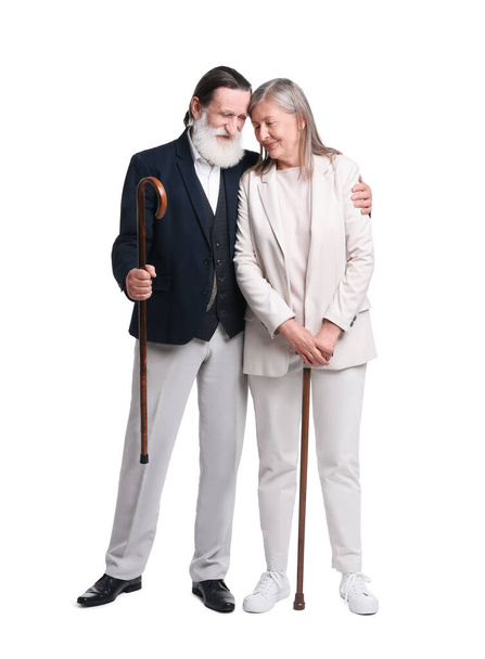 Senior man and woman with walking canes on white background - Foto, imagen