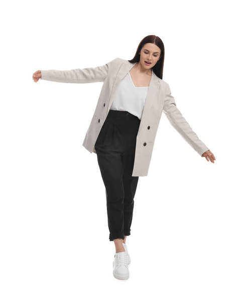 Beautiful businesswoman in suit walking on white background - Фото, изображение