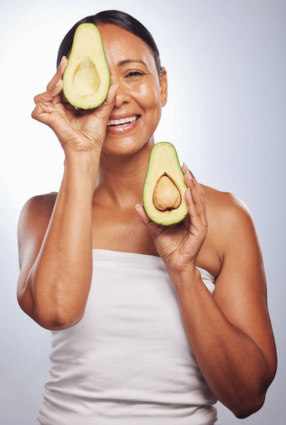 Senior, health and portrait of woman with avocado for skincare, nutrition or diet. Happy, face and elderly model or lady with food for wellness, beauty and detox isolated on a studio background. - Zdjęcie, obraz