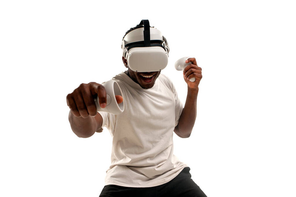african american male boxer plays and fights in virtual reality glasses on white isolated background, the guy uses modern vr gadget and plays virtual boxing - Fotoğraf, Görsel