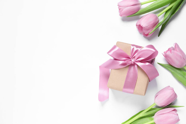 Beautiful gift box and tulips on white background, flat lay. Space for text - Fotografie, Obrázek